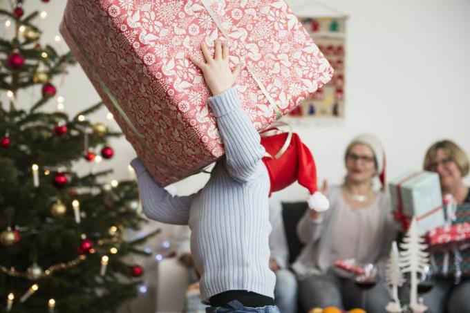 Väike poiss, kes kannab jõulude ajal suurt pappkasti