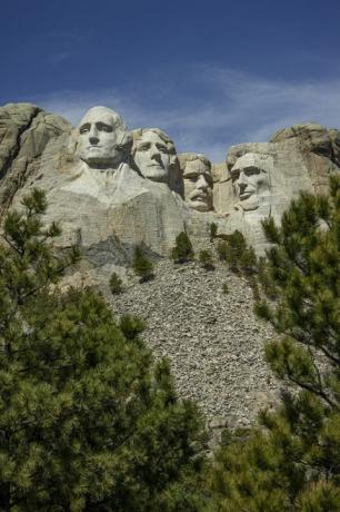 Mount rushmore'i riiklik monument Jeffersoni, Lincolni, Teddy Roosevelti ja Washingtoni kivipeadega taustal sinise taevaga