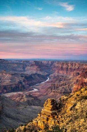 maaliline vaade Grand Canyoni rahvuspargile, taustal päikeseloojang ja seda läbiv jõgi