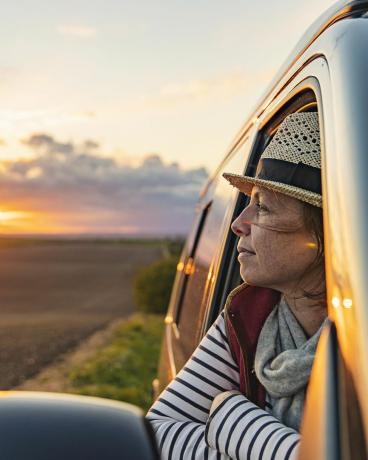 40ndates eluaastates naine vaatab matkaautost vaadet maale, tundub rahulolev ja pingevaba