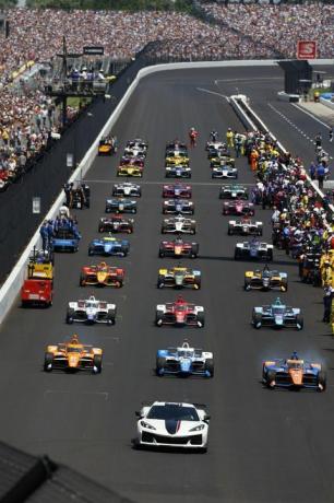 Indianapolis 500 eestvaates autod võidusõidurajal rivis ja inimesed tribüünidel